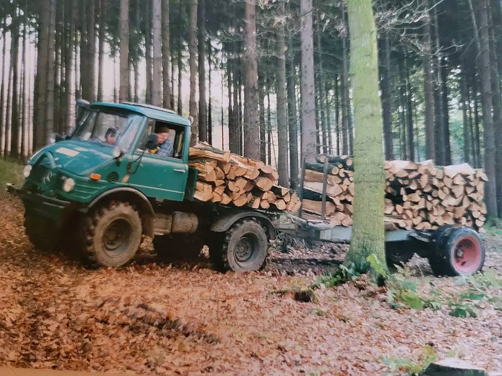 Historisches Foto aus den Anfängen von Forstwirt Gartenbau Spürkel mit Unimog beim Holztransport im Wald.